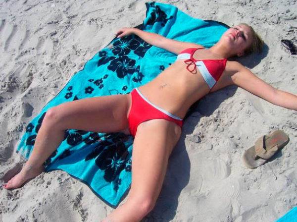 Телочка переодевает купальник в раздевалке на пляже